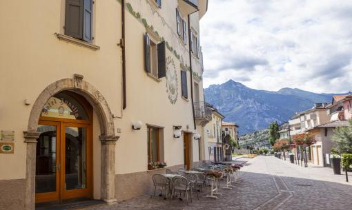 Peaceful mountain street with hotel, tables, and breathtaking view.